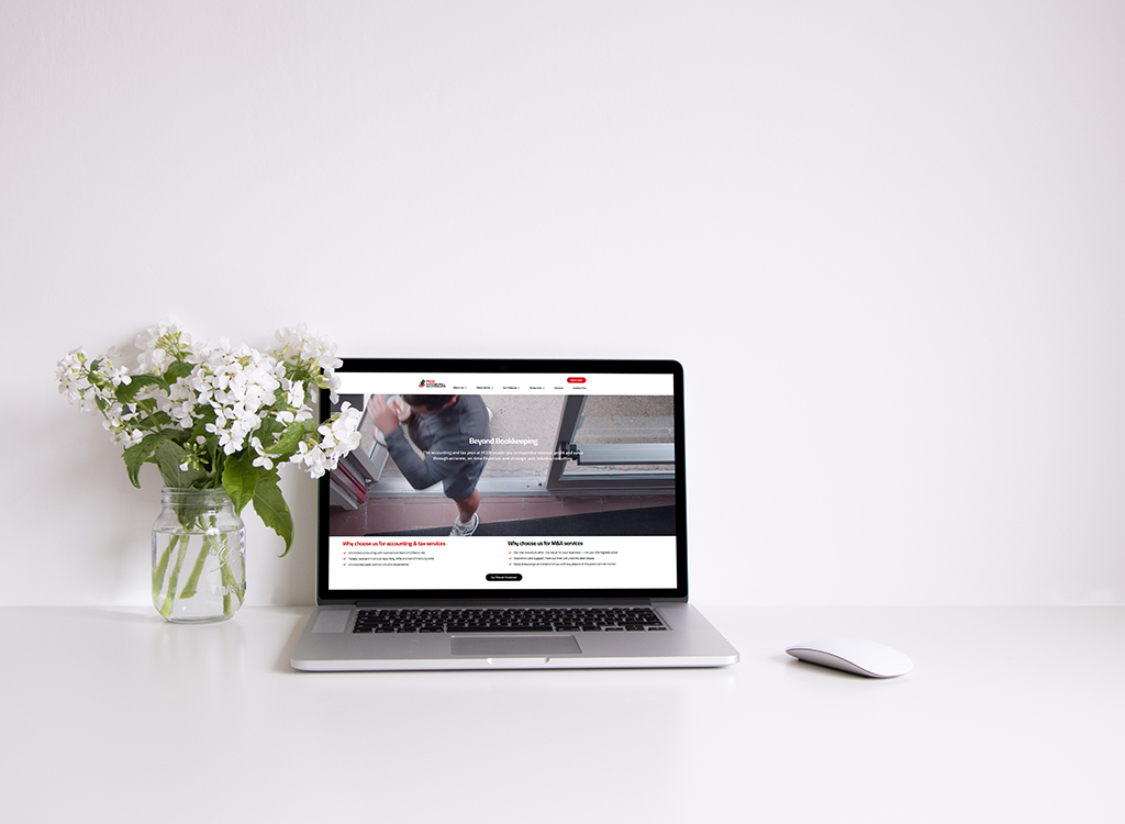 A modern laptop displaying a website on bookkeeping services, accompanied by a vase of white flowers on a clean desk. The screen features a professional layout highlighting service offerings.