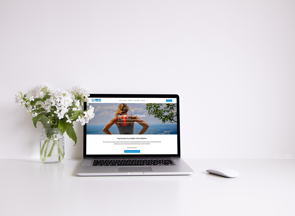 Laptop displaying a health improvement website on a clean desk with a vase of white flowers, emphasizing wellness and online health resources.